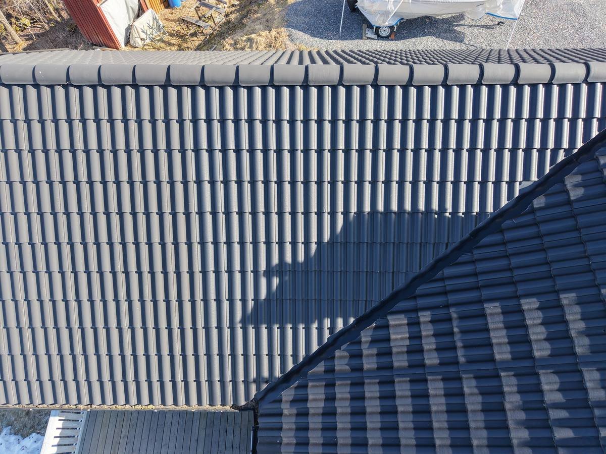 Aerial photo of tiled roof texture with the drone's own shadow visible on the roof